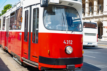 Naklejka premium Iconic red tram, picturesque timeless elegance public transport, journey through city, linking rich past with dynamic present, Vienna, Austria