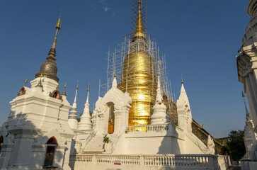 Fototapeta premium Whitewashed chedi of Wat Suan Dok covered with bamboo scaffolding in Chiang Mai, Thailand
