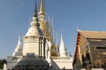 Whitewashed chedi of Wat Suan Dok covered with bamboo scaffolding in Chiang Mai, Thailand