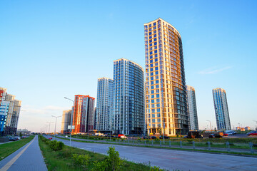 New residential buildings in residential complex. Bicycle path, pedestrian road in city. High multi-storey buildings. Modern apartment buildings. Colorful multi-story buildings on sunset. Housing