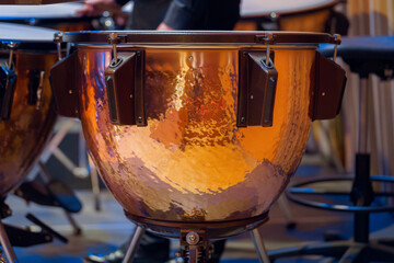 Close-up of a timpani drum during a live concert performance, showcasing its copper texture and...