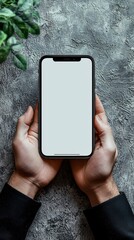 Close-up of hands holding smartphone with white screen. Mockup