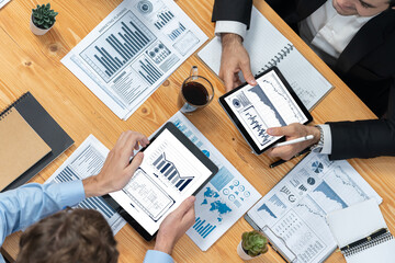 Financial data analysis dashboard by Fintech BI or business intelligence display on tablet screen to in-depth financial data analysis by business people planning marketing on table. Meticulous