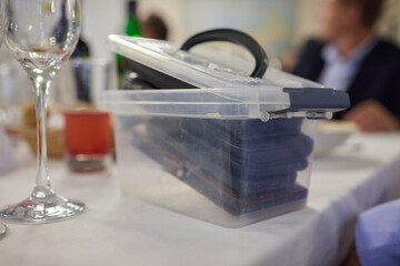 A Compact Storage Container Positioned on the Table Featuring Various Pieces of Glassware inside phones so you don't get distracted during dinner
