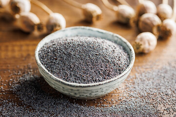 Dry head and poppy seed in bowl on kitchen table.