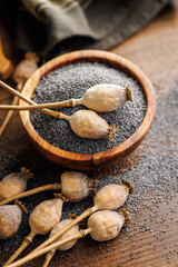 Dry head and poppy seed in bowl on kitchen table.