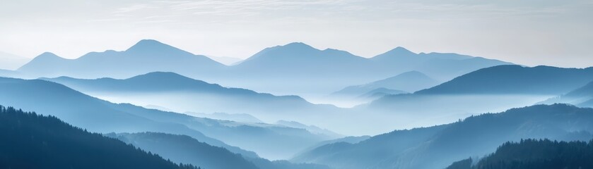 Obraz premium Serene mountain landscape with layers of mist and blue hues, conveying tranquility and natural beauty in a panoramic view of undulating peaks.