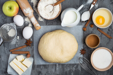 The process of making a pie. Ingredients, products and kitchen utensils for making apple and cinnamon pie. Top view, horizontal.