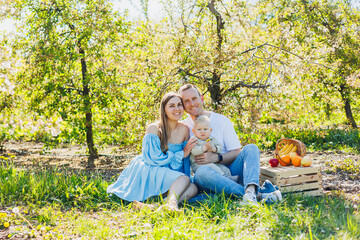 Father and mother holding little son in nature, concept of beautiful family bonds. Family portrait of parents with a little son. The concept of a happy family