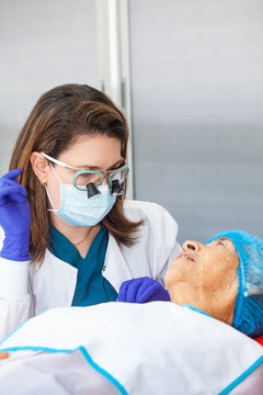 Dermatologist carrying out a skin biopsy on the face of a senior adult patient
