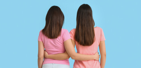 Beautiful hugging women on blue background