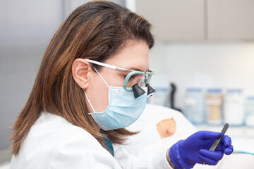 Dermatologist carrying out a skin biopsy on the face of a senior adult patient