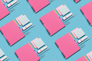 Notebook, highlighter, pen, push pins and paper sheets on blue background. Office and school supplies on blue background. Back to school concept