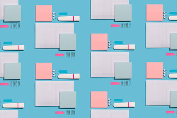 Highlighter, pen, push pins and paper sheets on blue background. Office and school supplies on blue...