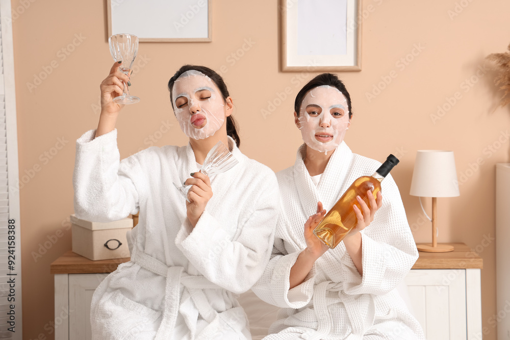 Poster Beautiful young women with facial masks, bottle of wine and glasses in bedroom