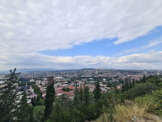 view on Trees and Tbilisi (the capital from Georgia) from a Hill, atmospheric and blue cloudy sky, travelling photography, exploring Georgia