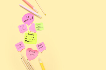 Sticky notes with to do plans and stationery on yellow background. New year goals concept