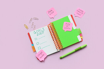 Notebook with empty to do list, sticky notes and stationery on lilac background. New year goals...