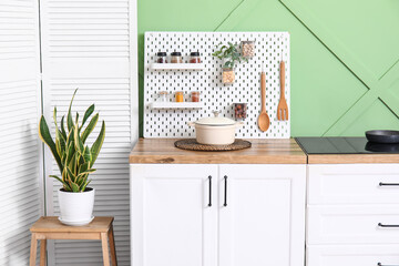 Interior of modern kitchen with pegboard and stove