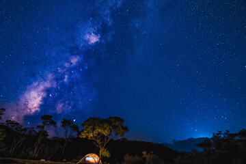 Naklejka premium A tent pitched under a starry night sky with the Milky Way visible.