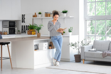 Thoughtful middle-aged woman with notebook trying to remember something at home. Reminder concept