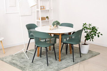 Interior of light dining room with table and shelf unit