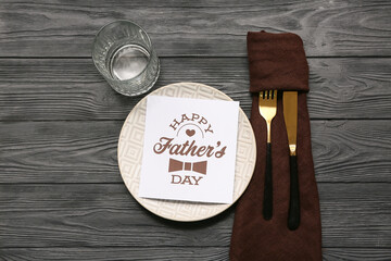 Festive decorated table setting with greeting card on black wooden background. Father day celebration concept