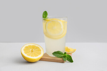 Glass of fresh lemonade with mint on grey background