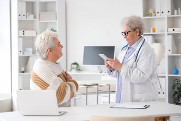 Obraz premium Senior doctor working with patient in clinic