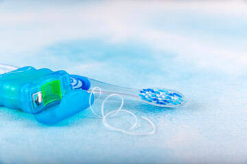 Dental floss and toothbrush on blue background. Tongue cleaner and other oral care products, dental hygiene concept.