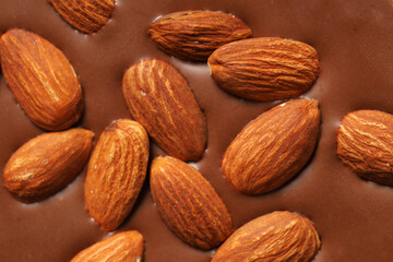 Texture of sweet chocolate with almond nuts as background, closeup