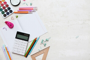 Composition with blank copybook, different stationery and calculator on light background