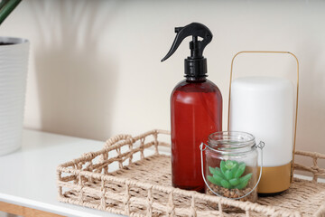 Tray with aroma spray, plant and lamp on shelf in room, closeup