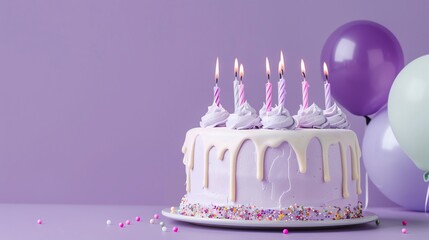 A purple birthday cake with white frosting and lit candles sits in front of a purple and green...