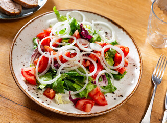 Delicious fresh vegetable salad with tomato and onion served on plate