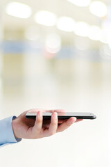 Man hand holding black smart phone over blur background with copy space, template, technology and lifestyle