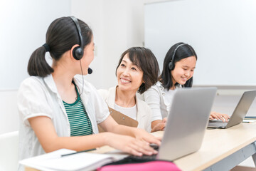 パソコンを使ってICT教育する先生と子供（女の子・日本人）
