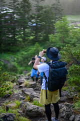 登山で写真を撮る男性