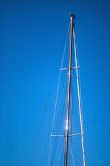 Silver Sail Boat Mast with Sunlight Reflections.