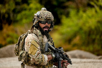 Fototapeta premium A group of military men in combat gear patrol in the middle of a desert and tropical jungle. Soldiers in full combat gear in dry weather conditions assemble and march on a mission.