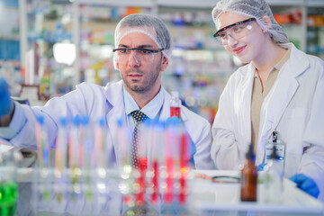 scientists perform experiments and record data. people arranges equipment with test tubes and chemicals for producing medicine and biochemistry. man hold tubes of chemical liquids and plant samples.