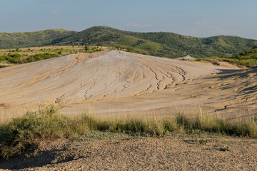 Arid landscape near Berca, Buzau, Romania, showcasing a rare European geological phenomenon. Here, gases from the earth emerge through the hills, creating small mud volcanoes and distinctive landscape