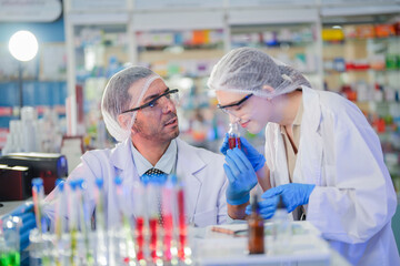 scientists perform experiments and record data. people arranges equipment with test tubes and chemicals for producing medicine and biochemistry. man hold tubes of chemical liquids and plant samples.