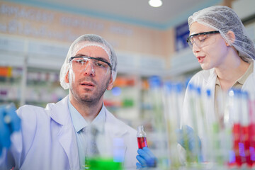 scientists perform experiments and record data. people arranges equipment with test tubes and chemicals for producing medicine and biochemistry. man hold tubes of chemical liquids and plant samples.