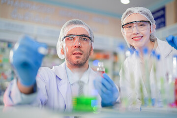 scientists perform experiments and record data. people arranges equipment with test tubes and chemicals for producing medicine and biochemistry. man hold tubes of chemical liquids and plant samples.