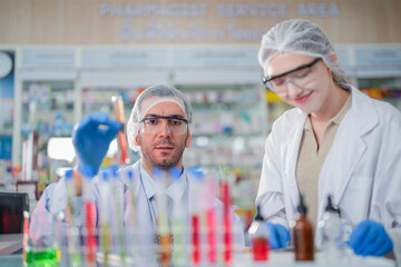 scientists perform experiments and record data. people arranges equipment with test tubes and chemicals for producing medicine and biochemistry. man hold tubes of chemical liquids and plant samples.