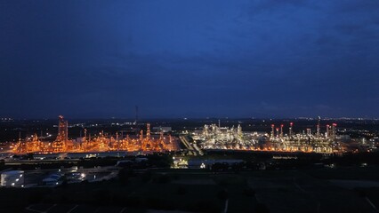 High angle view of industrial plant with pipes and tanks for mixing chemicals and gases at night.