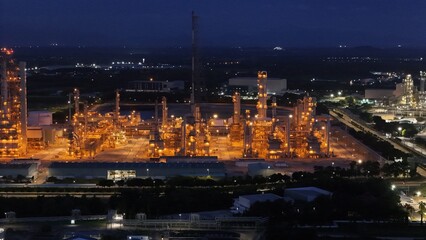 Fototapeta premium High angle view of industrial plant with pipes and tanks for mixing chemicals and gases at night.
