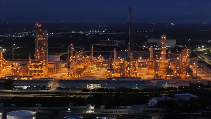 High angle view of industrial plant with pipes and tanks for mixing chemicals and gases at night.