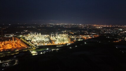 Fototapeta premium High angle view of industrial plant with pipes and tanks for mixing chemicals and gases at night.